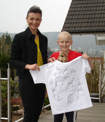 Strahlemaennchen überreicht ein unterschriebenes T-Shirt vom FC Bayern München